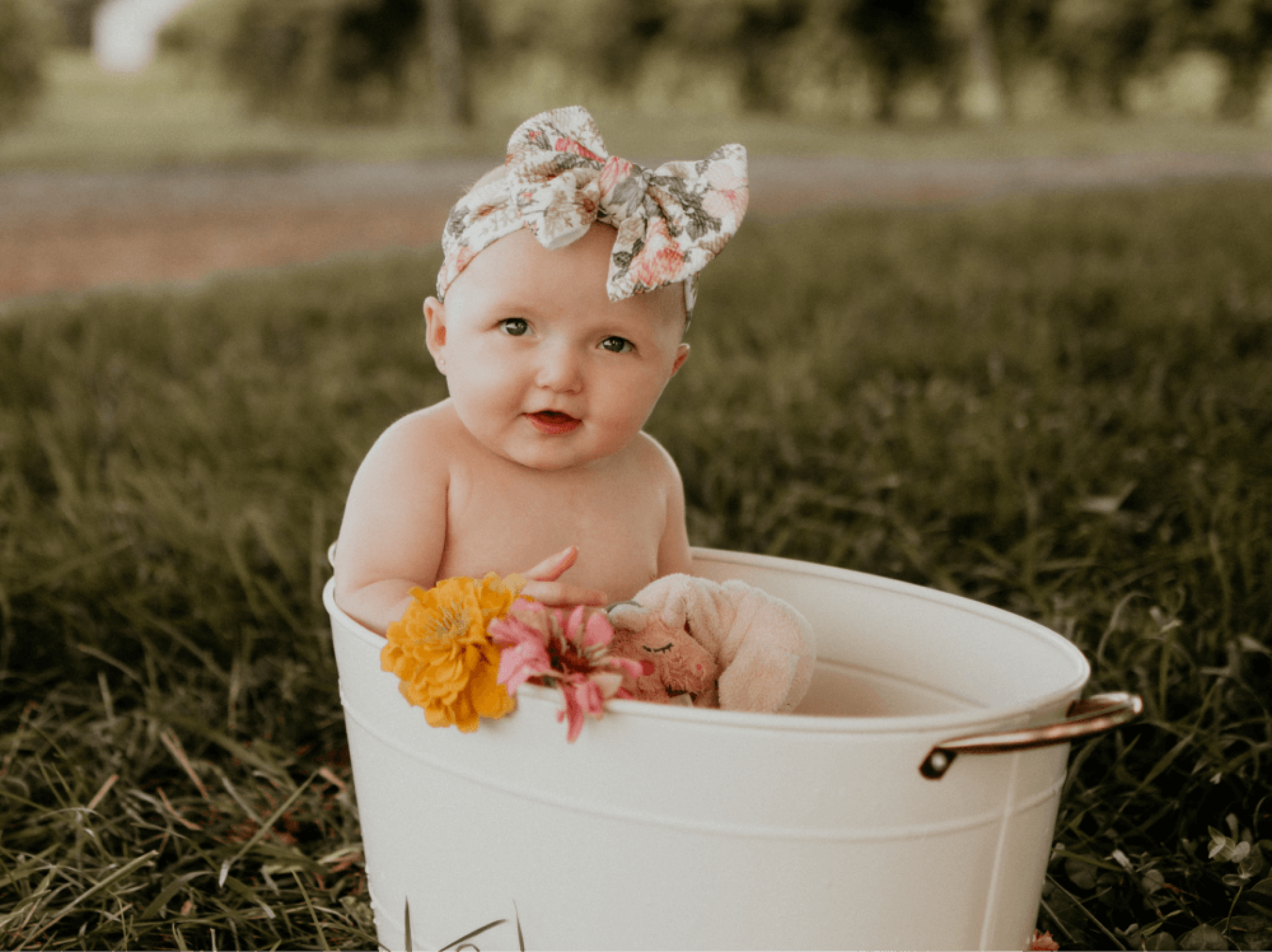 a baby in a bucket with flowers